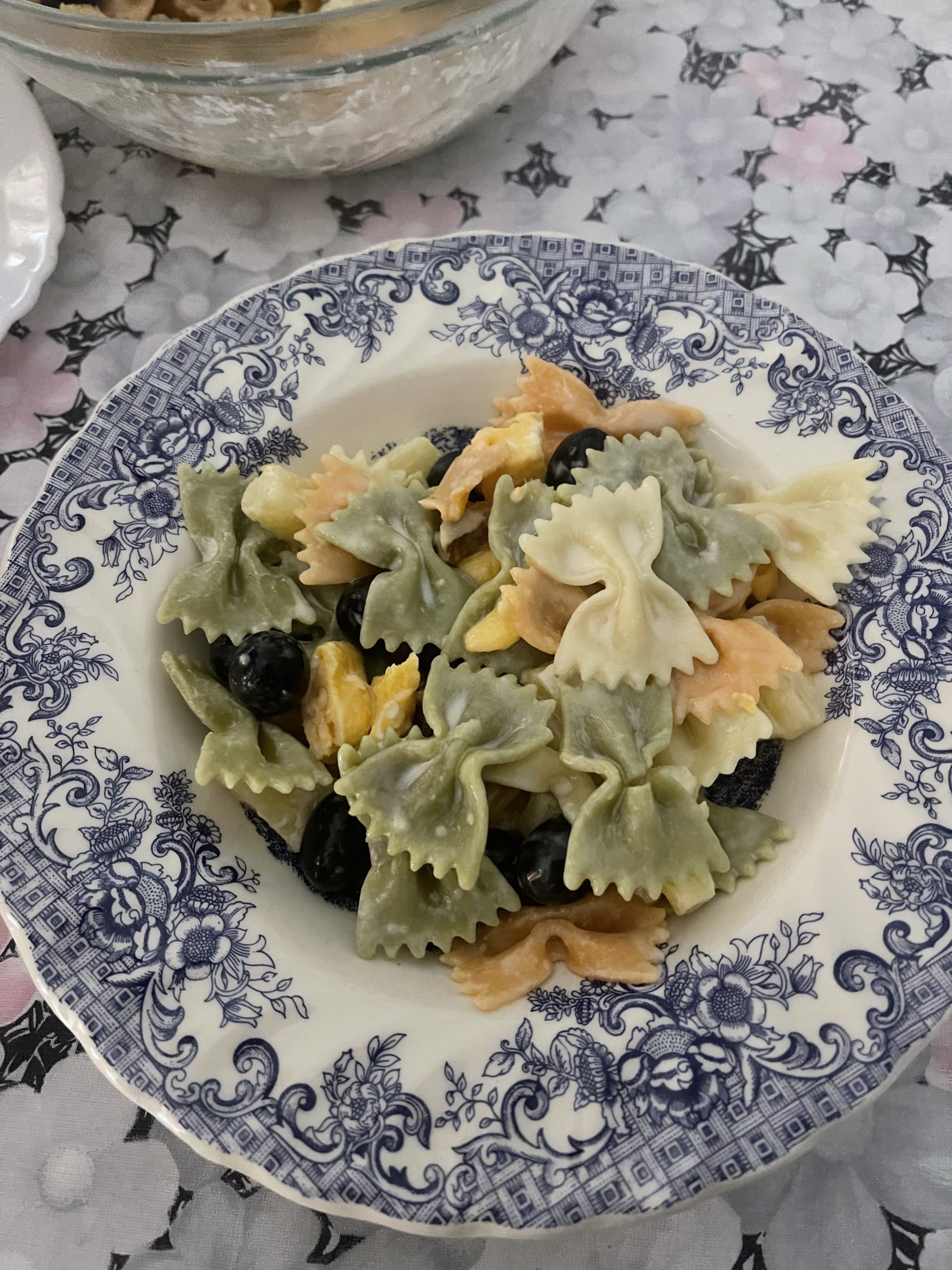 A picture of a bowl of pasta salad with bowtie noodles.